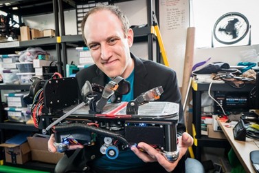Image of Founder Brad Factor holding wearable robotic footwear, EKTO One, from EKTO VR