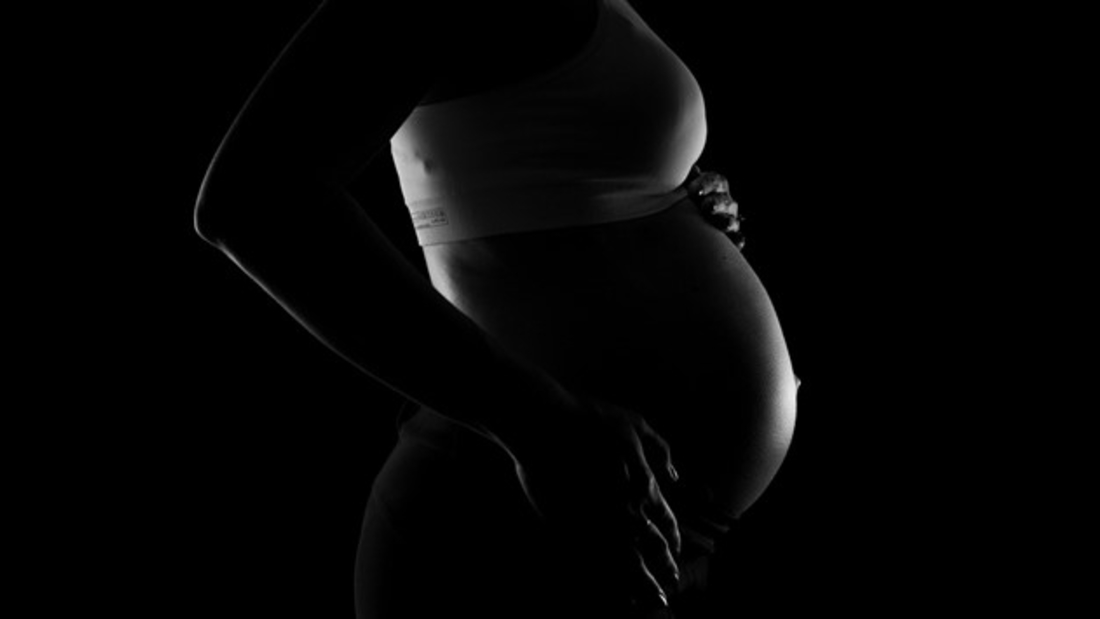 Black and white image of the profile of a pregnant woman